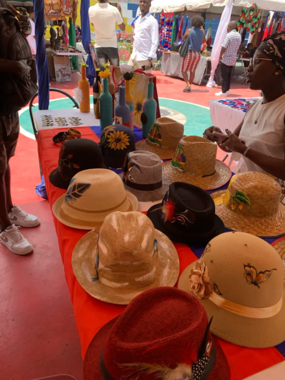 Handwoven hats and colorful craft on display at a Haitian market.